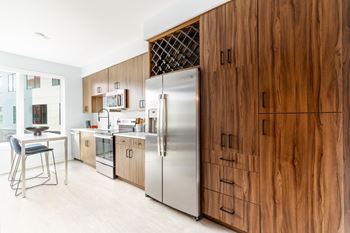 A kitchen with wooden cabinets and a stainless steel refrigerator